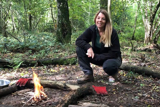 Engagement officer Faye Irvine next to a small campfire