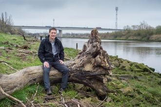 Jeremy sat on a log next to a river