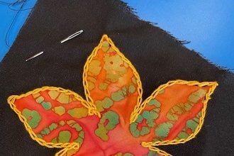 Applique leaf made from orange fabric on a black background
