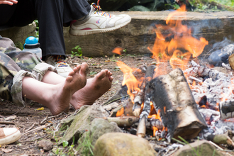 Bare feet warming by a campfire