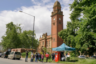 Photo of Leamington town hall with the peregrine watch stall and a queue of people in front