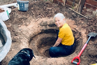 A women digging a wildlife pond in a nature allotment in Attleborough