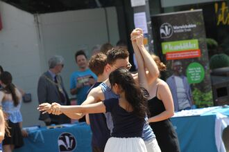 two salsa dancers with the warwickshire wildlife trust stall in background
