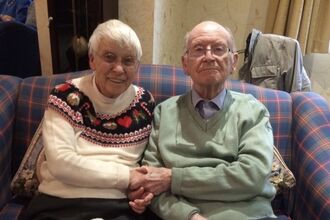 A couple sat next to each other on a couch