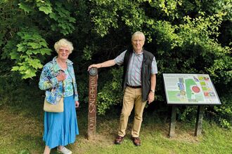 Ian and Sheila stand beside a post in Catherine's Wood