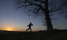 A child playing in nature at sunset