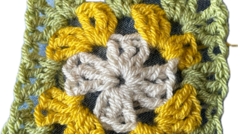 Crochet granny square in green yellow and cream yarn