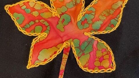 Applique orange leaf on a black fabric 