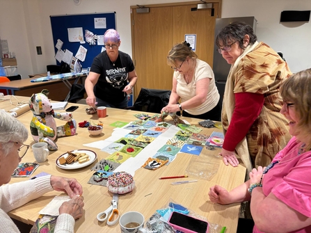 A group of ladies sewing patches onto the patchwork