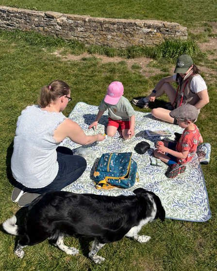 Group of people having a picnic (two adults, two children, one dog)