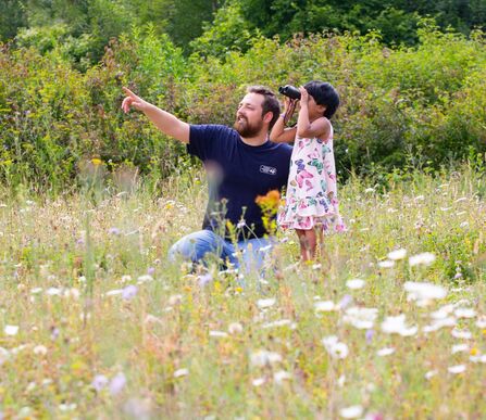Man and child using binoculars to spot wildlife