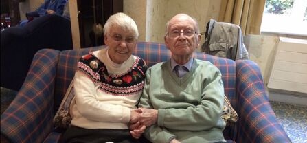 A couple sat next to each other on a couch