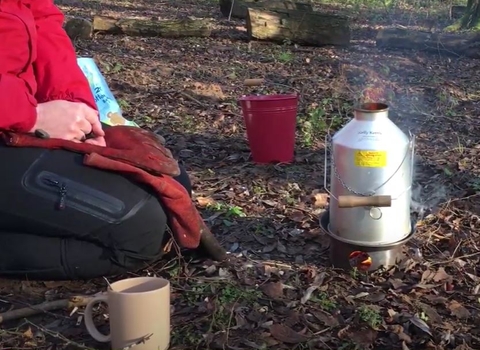 Kelly kettle being used in woodland
