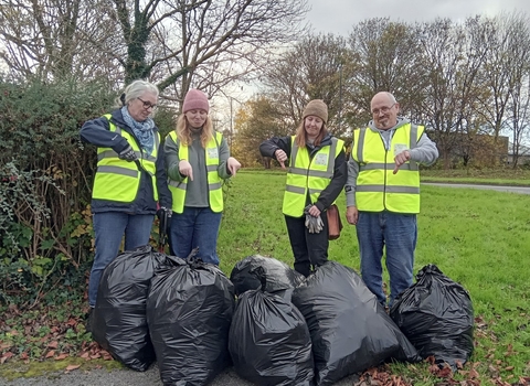 A group of people who have just completed a litter pick in Sydenham, they are all showing a thumbs down to the amount of litter bags they have gathered